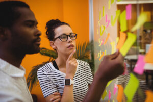 Un hombre y una mujer utilizan la metodología del Design Thinking para la resolución de problemas empresariales.